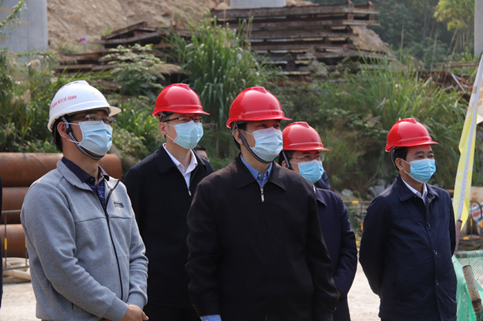 圖1:黃世勇(右三)在現場查看都巴高速主線紅水河特大橋施工情況.jpg